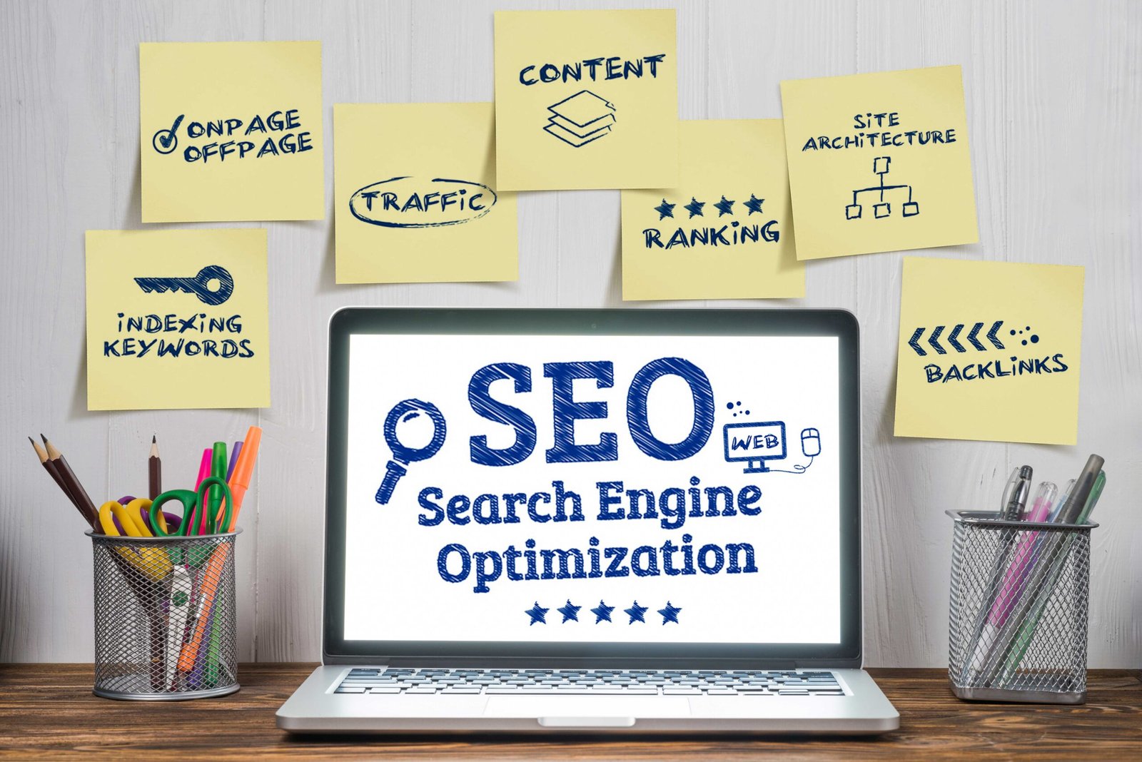 Laptop displaying SEO search engine optimization surrounded by sticky notes highlighting on-page SEO, content, and traffic.